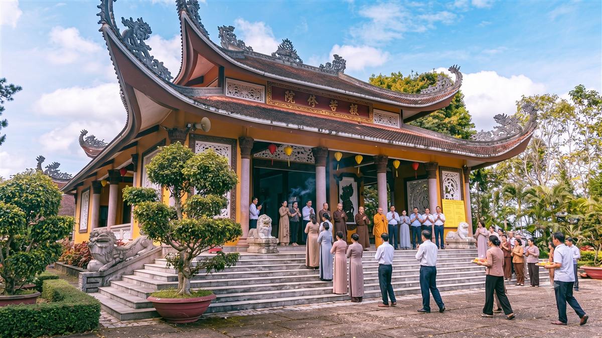 Chánh điện Tu viện Bát Nhã với mái ngói cong, tường vàng và Phật tử đang dâng hương