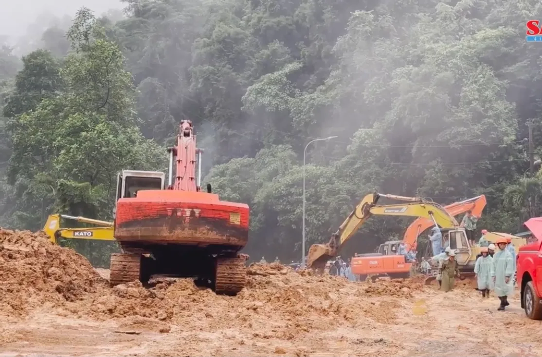 Máy múc dọn đất đá sạt lở trên một cung đèo ở Lâm Đồng