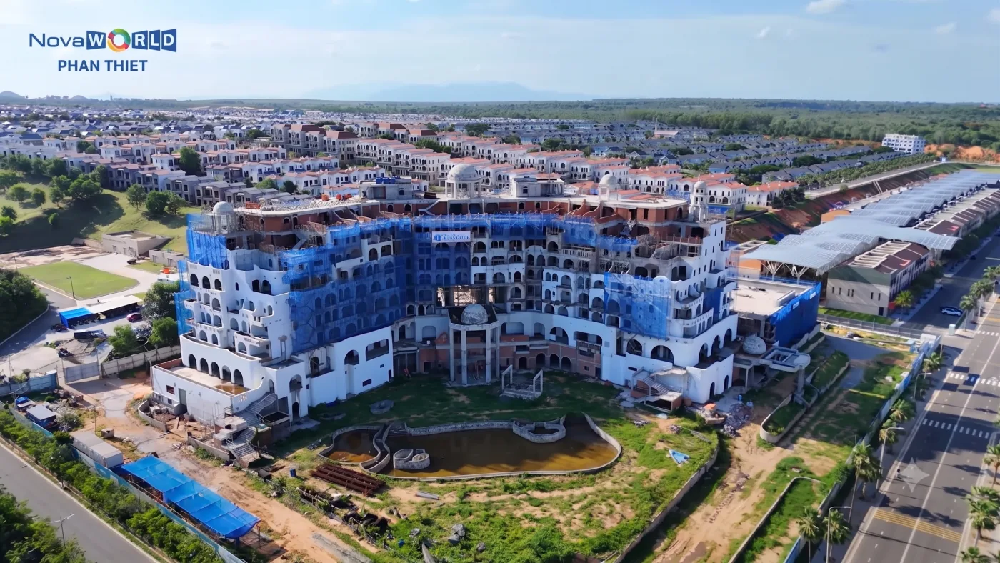 Ảnh chụp từ trên cao khách sạn Novotel Phan Thiết kiến trúc Santorini xanh trắng đang hoàn thiện, xung quanh là các dãy nhà thấp tầng đã xong