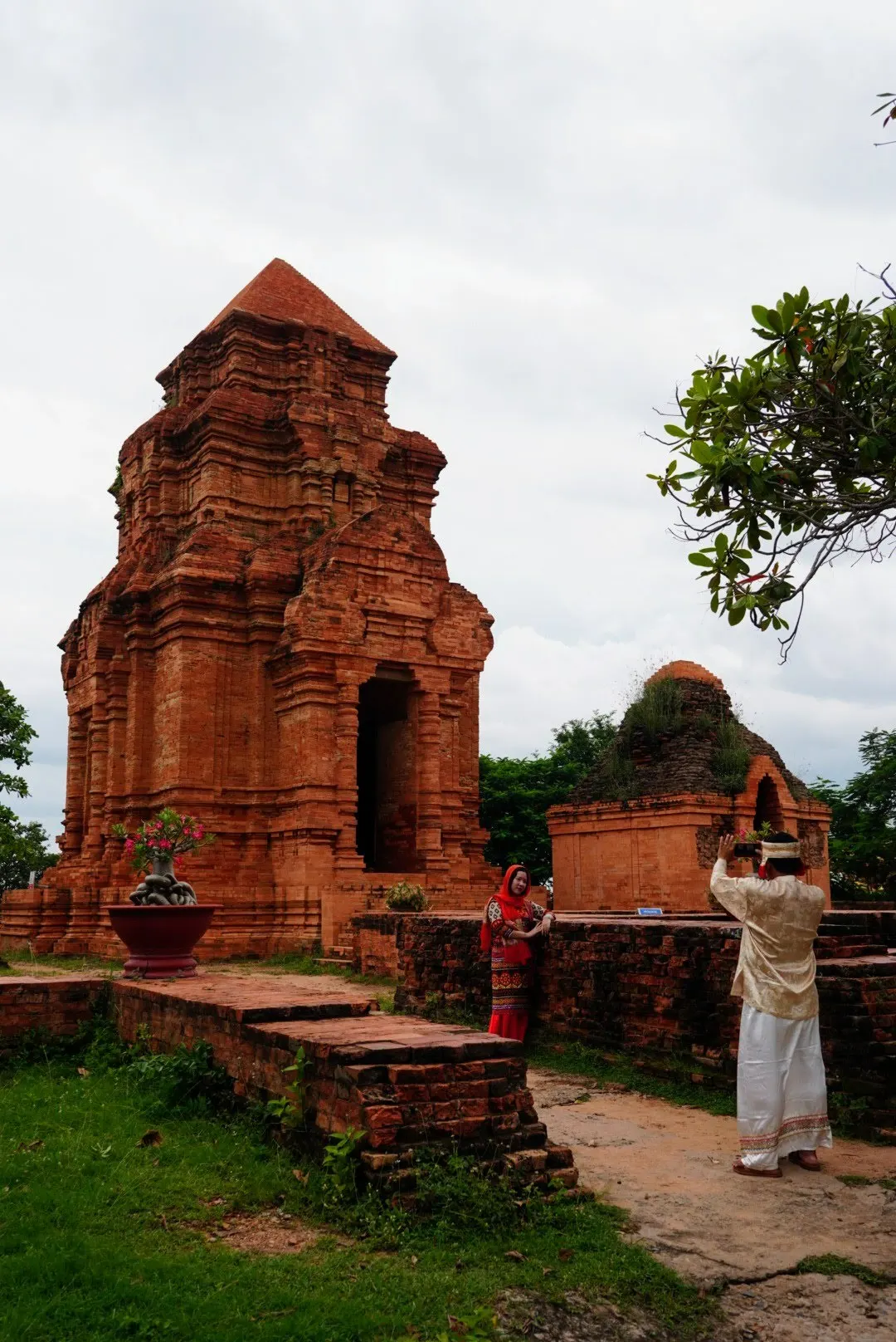 Du khách mặc trang phục truyền thống chụp ảnh trước tháp Chăm ở Mũi Né