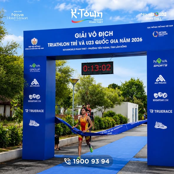 Vận động viên mang bib HOANG lao qua cổng đích, đồng hồ điện tử phía trên ghi 0:16:20